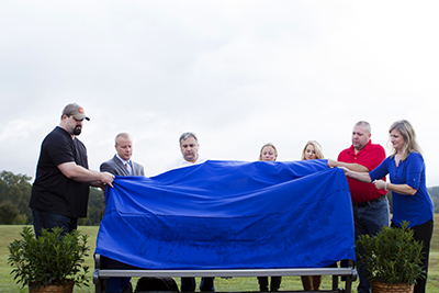 Survivors unveil a memorial bench.