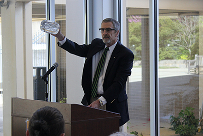 Photo of Warren Daubenspeck holding up a vintage ashtray