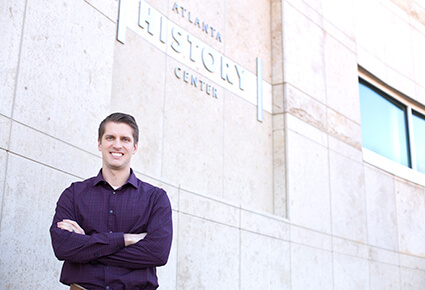 Photo of University of West Georgia alumnus Jess Garbowski standing in front of the Atlanta History Center