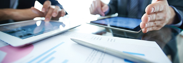 Close up photo of people using ipads at a table.