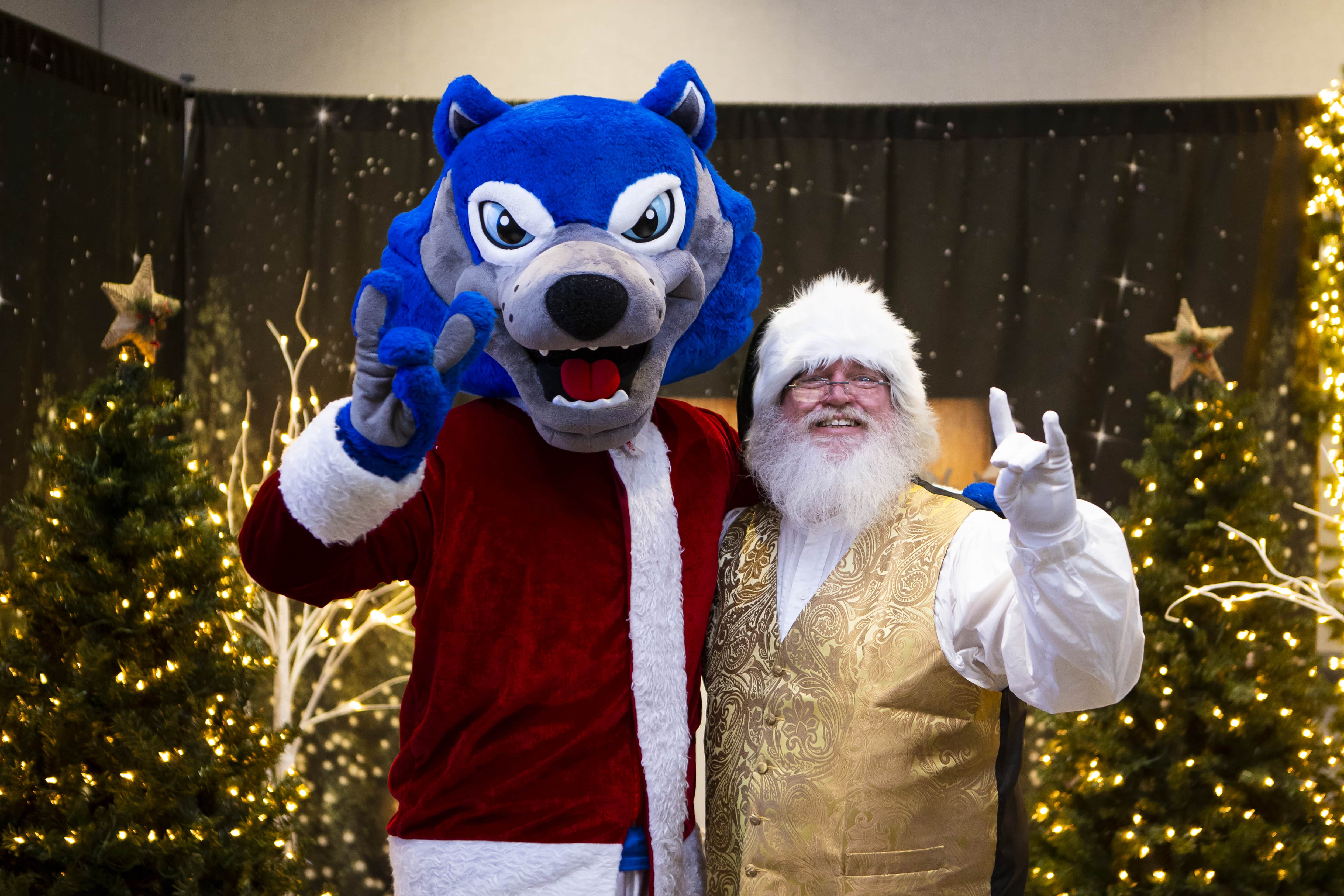 Santa Claus and Wolfie posing for a picture.